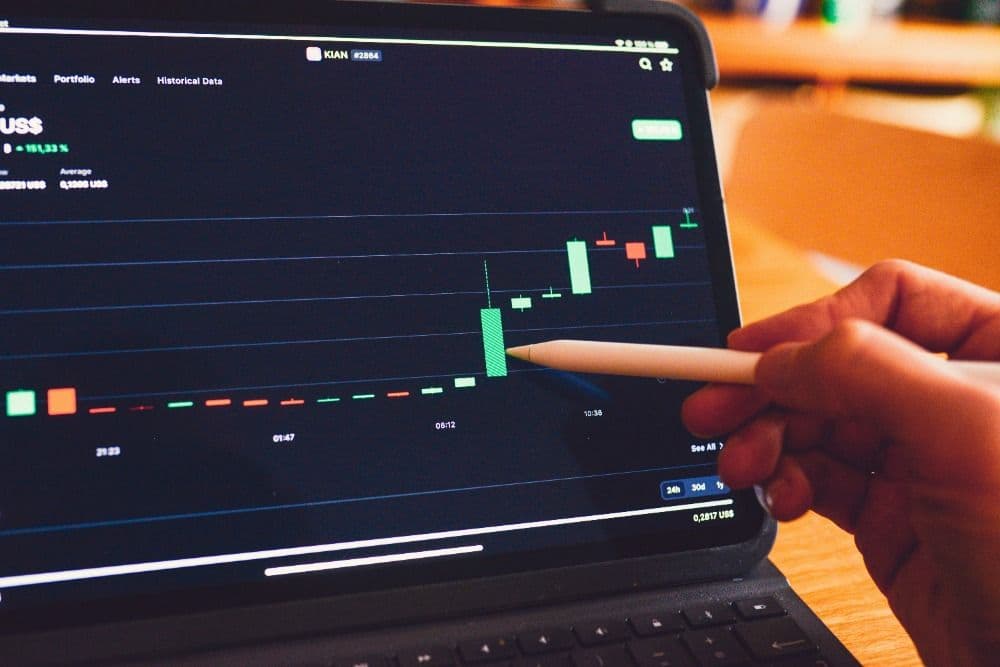 Apple pencil pointing at a graph on a laptop screen
